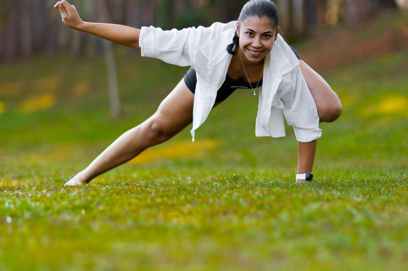 Aline Rebeka em postura de yoga ao ar livre